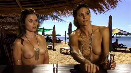 As meninas se divertem em uma praia nudista
