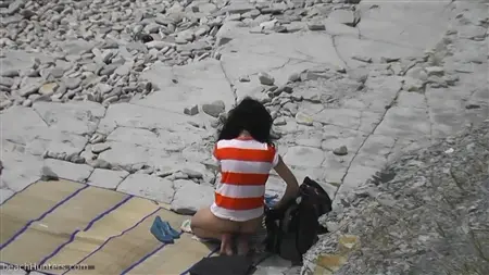 O pervertido está espionando as meninas na praia nudista