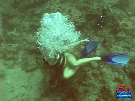 Um aqualangista nu está procurando tesouros no fundo do oceano
