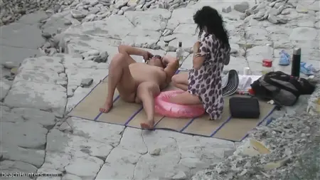 Namoradas sacangas com peitos nus relaxam em uma praia deserta