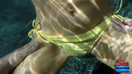 Uma mulher em um maiô se masturba debaixo d'água