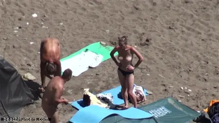 Os nudistas ávidos desfrutam de férias em sua praia selvagem favorita